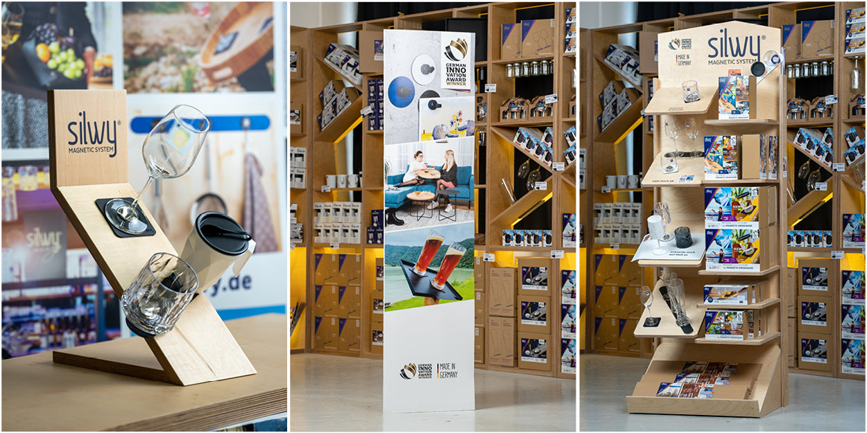 Foto 1: hölzerner, schiefer silwy Aussteller mit einem Magnet-Kristallglas WEIN, einem Magnet-Kunststoffglas TUMBLER und der weißen Magnet-Kunststofftasse TO-GO; Foto 2: Kartonaufsteller mit Fotos vor Regalen die mit silwy Produkten gefüllt sind; Foto 3: hölzerner silwy Aufsteller vor Regalen die mit silwy Produkten gefüllt sind