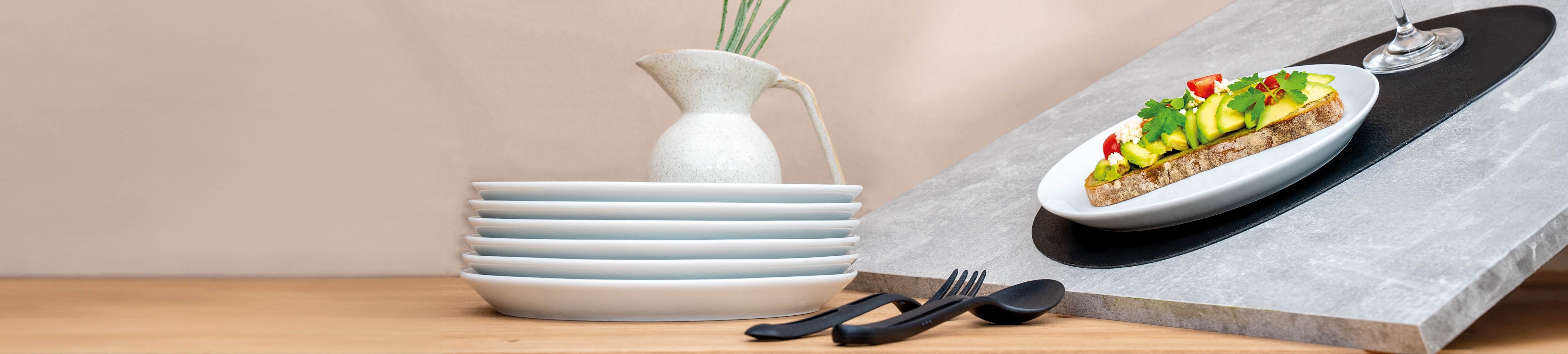 Magnet-Porzellan-Teller gestapelt und auf Platzset schiefgestellt