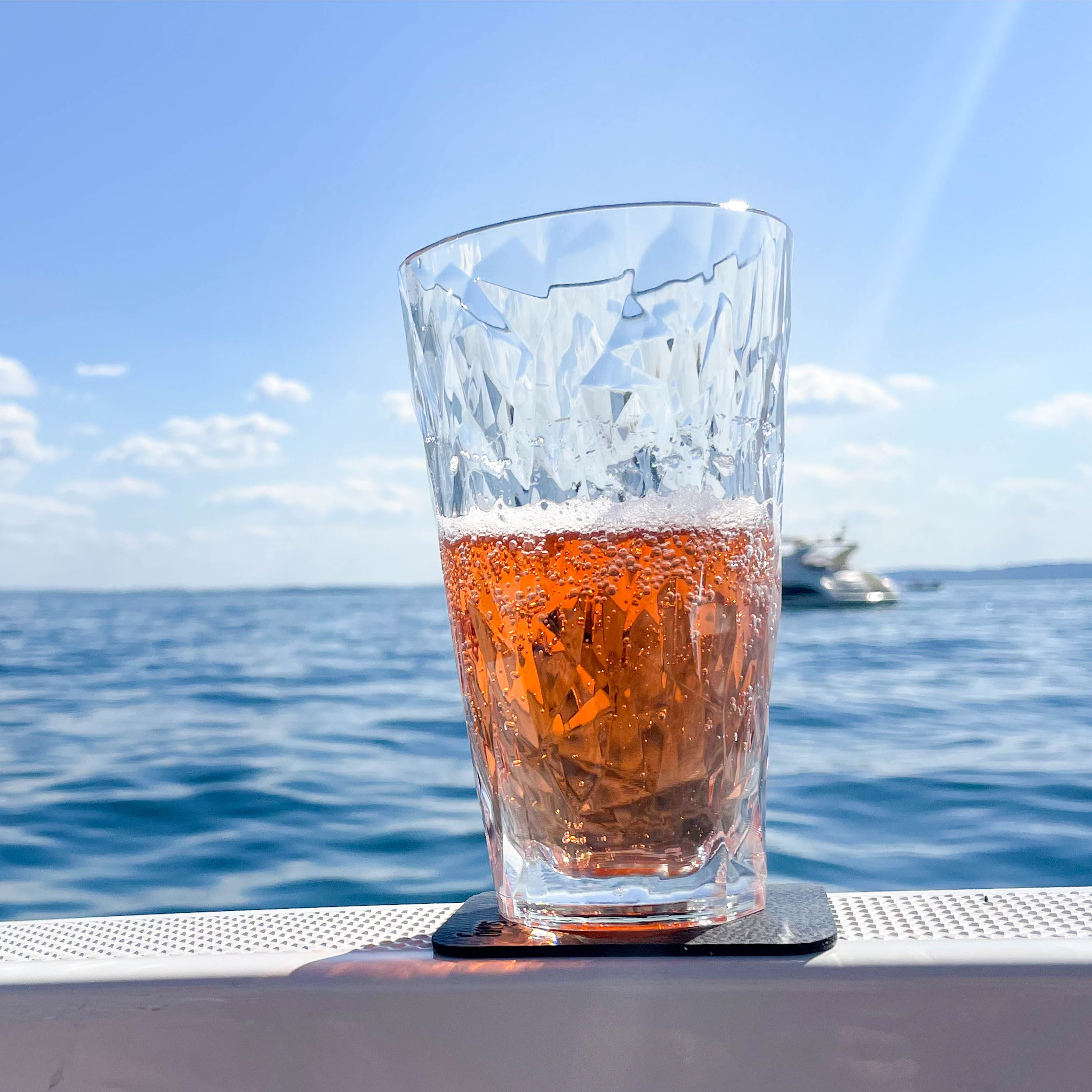 Magnet-Kunststoffglas Longdrink abgestellt auf einem Pad auf einem Boot während der Fahrt