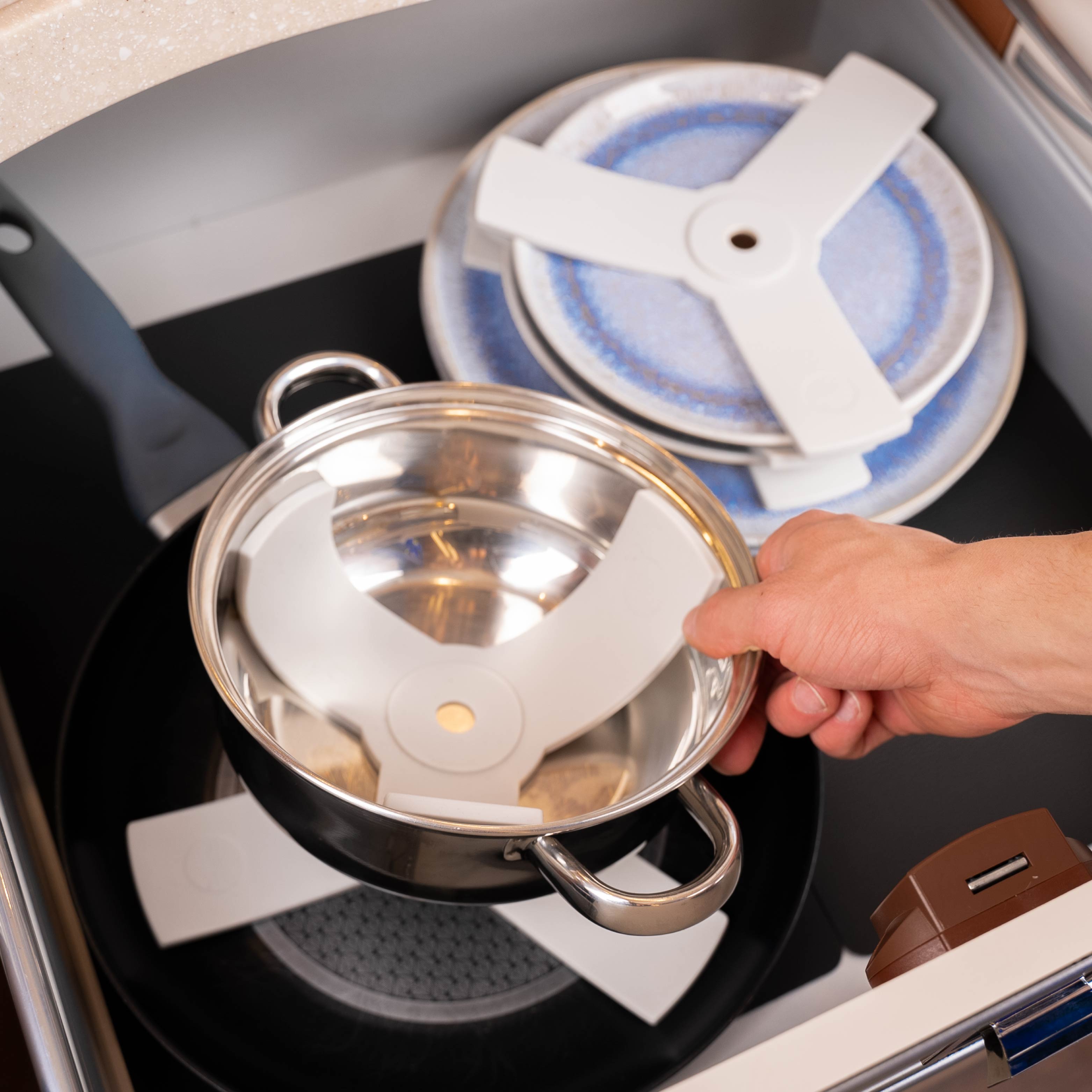 Magnet-Teller aufeinander gestapelt mit Sandwich sowie Pfannen und Töpfe mit Sandwich gestapelt