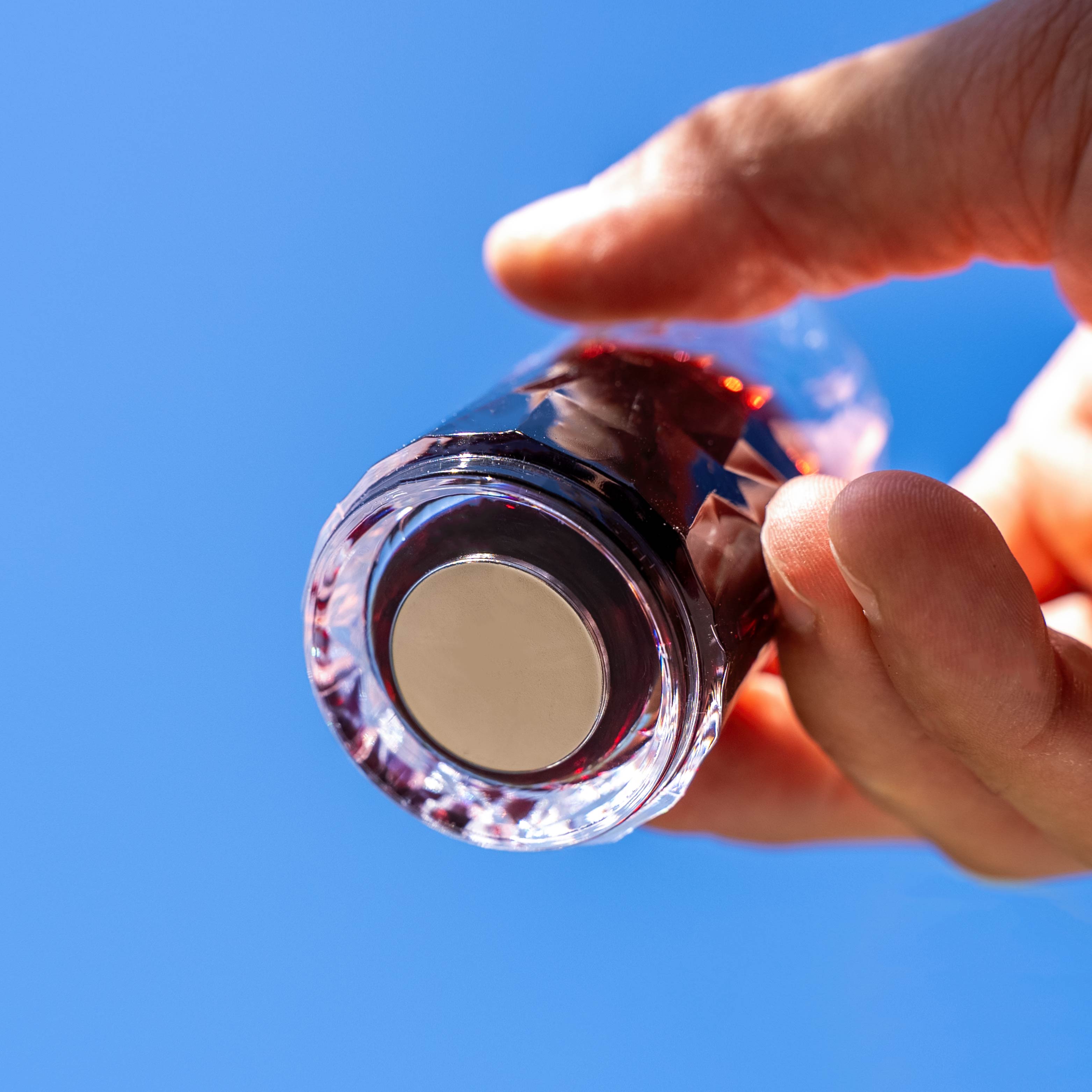Magnet-Kunststoffglas Shot mit integriertem Magnet im Boden vor blauem Hintergrund