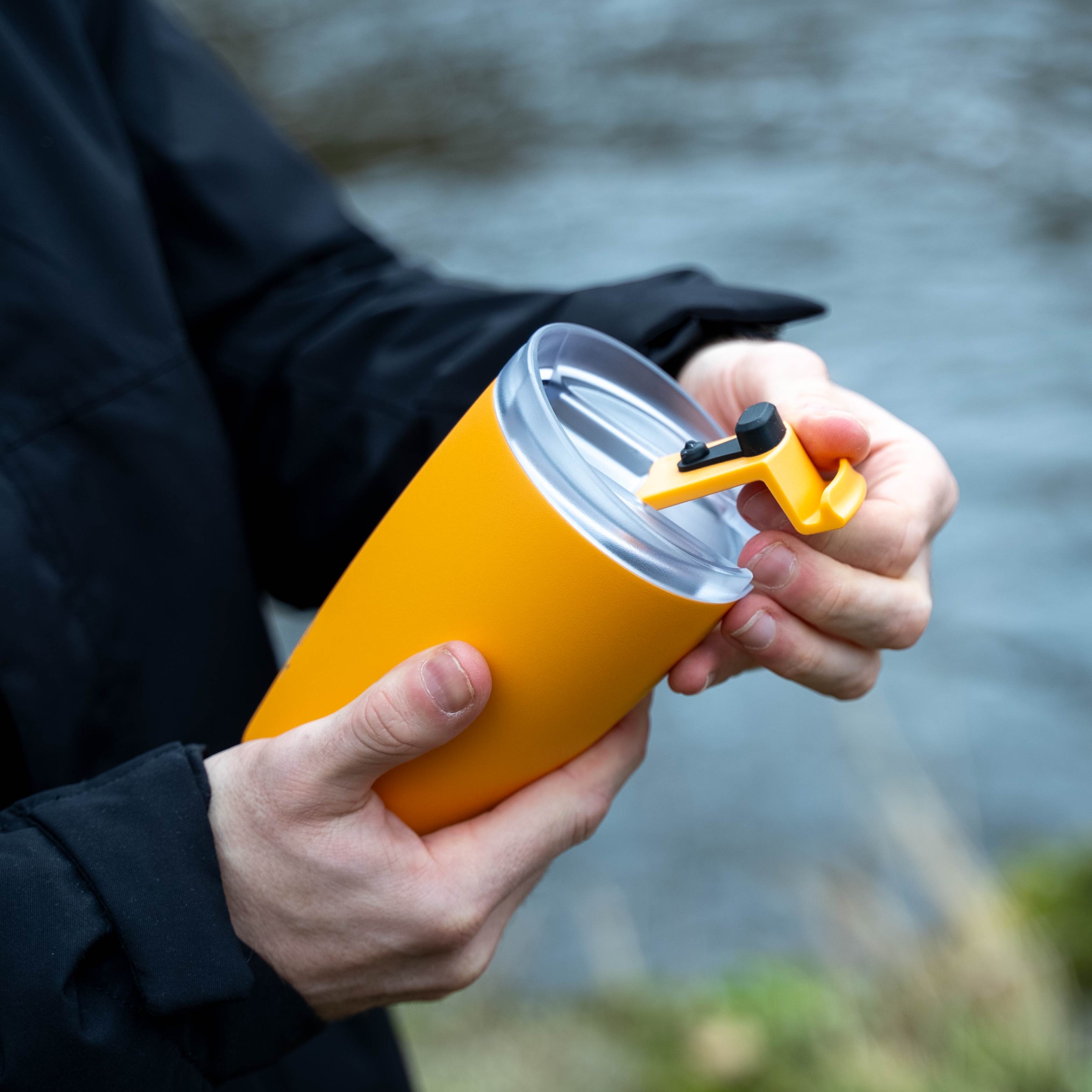 Der silwy x FLSK Thermocup in der Farbe sunrise ist geöffnet und wird in der Hand gehalten