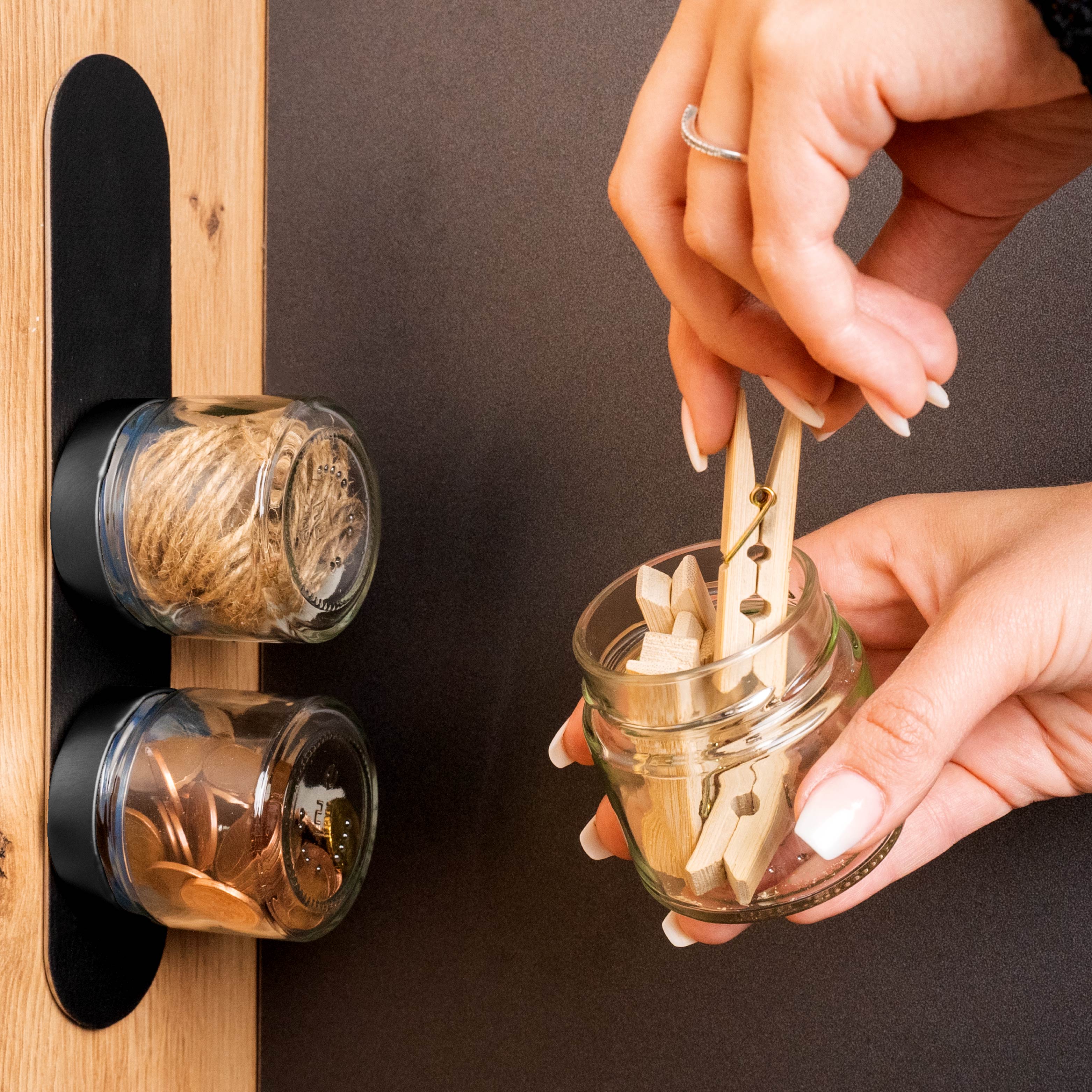 Magnet-Feinkostgläser an Metall-Leiste fixiert, die mit Büroutensilien befüllt sind