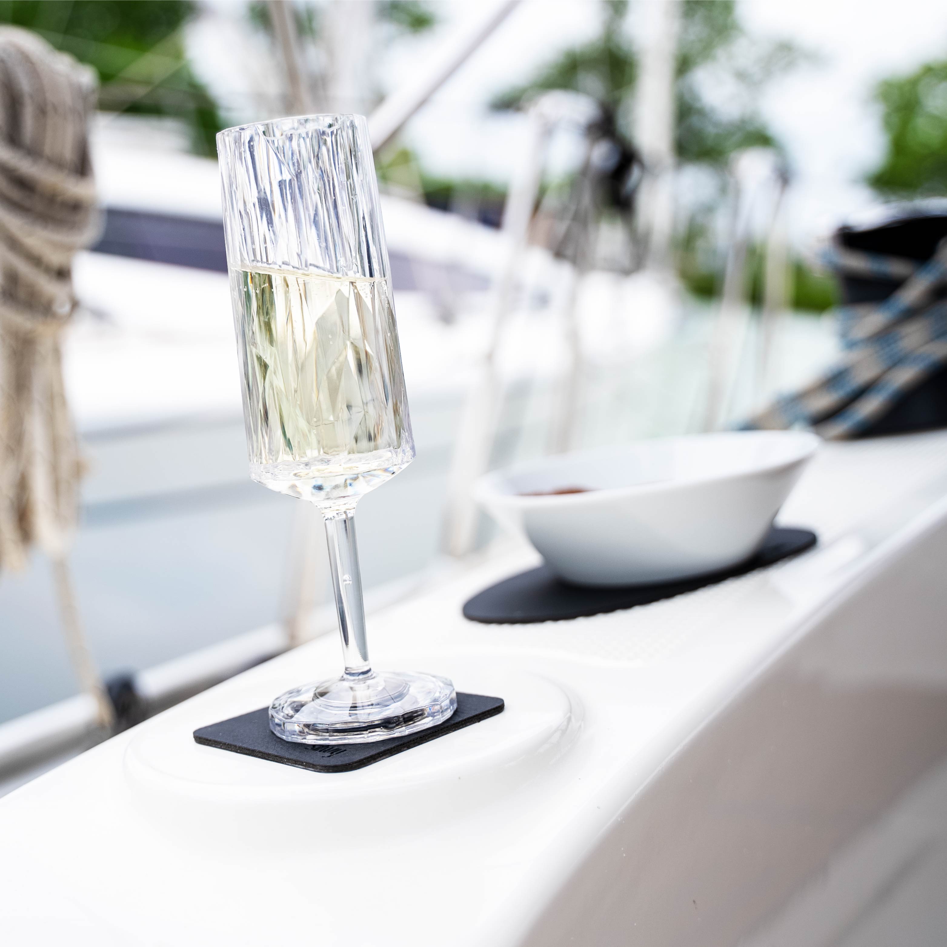 Magnet-Kunststoffglas Sekt auf einem Pad auf einem Boot in Schräglage